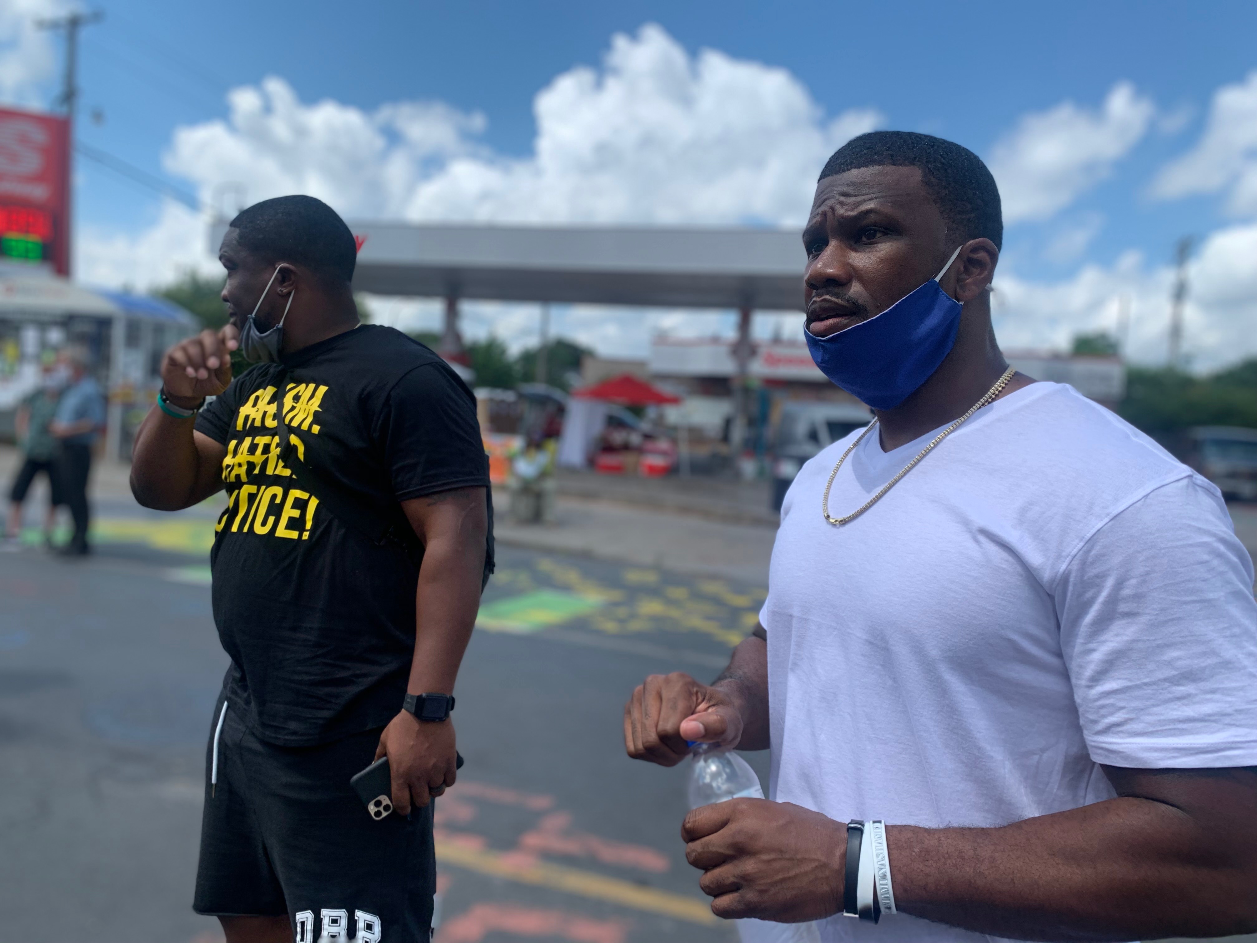 Mentors standing at an outdoor community gathering