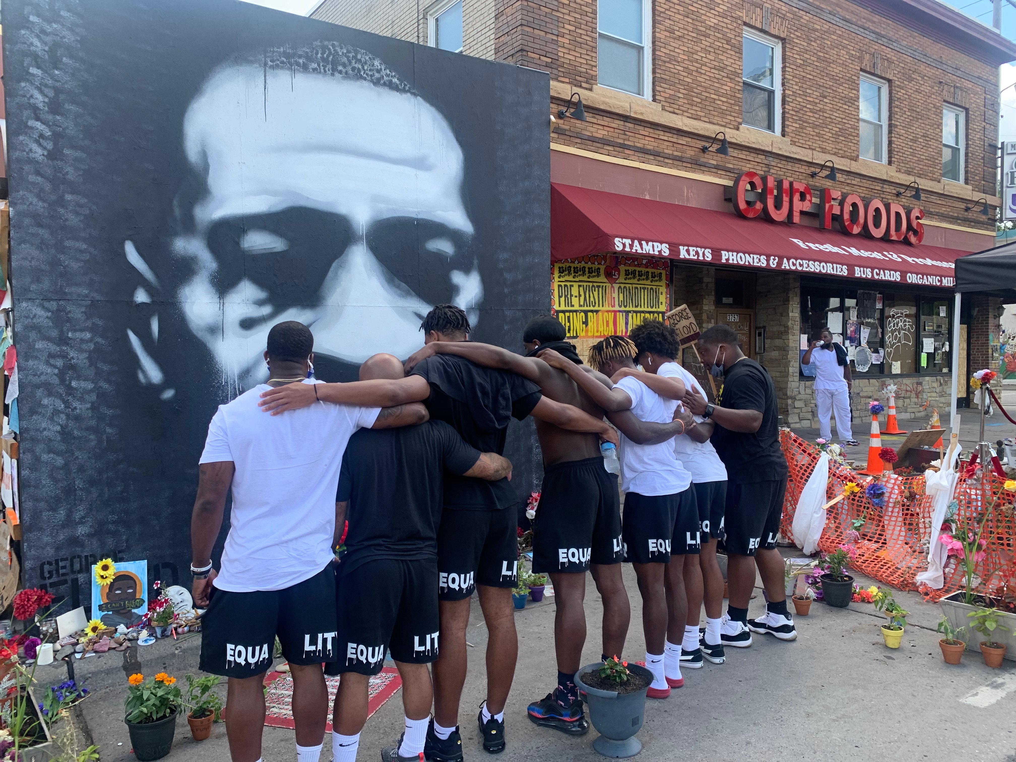 Youth and mentors gathered together at a community memorial mural