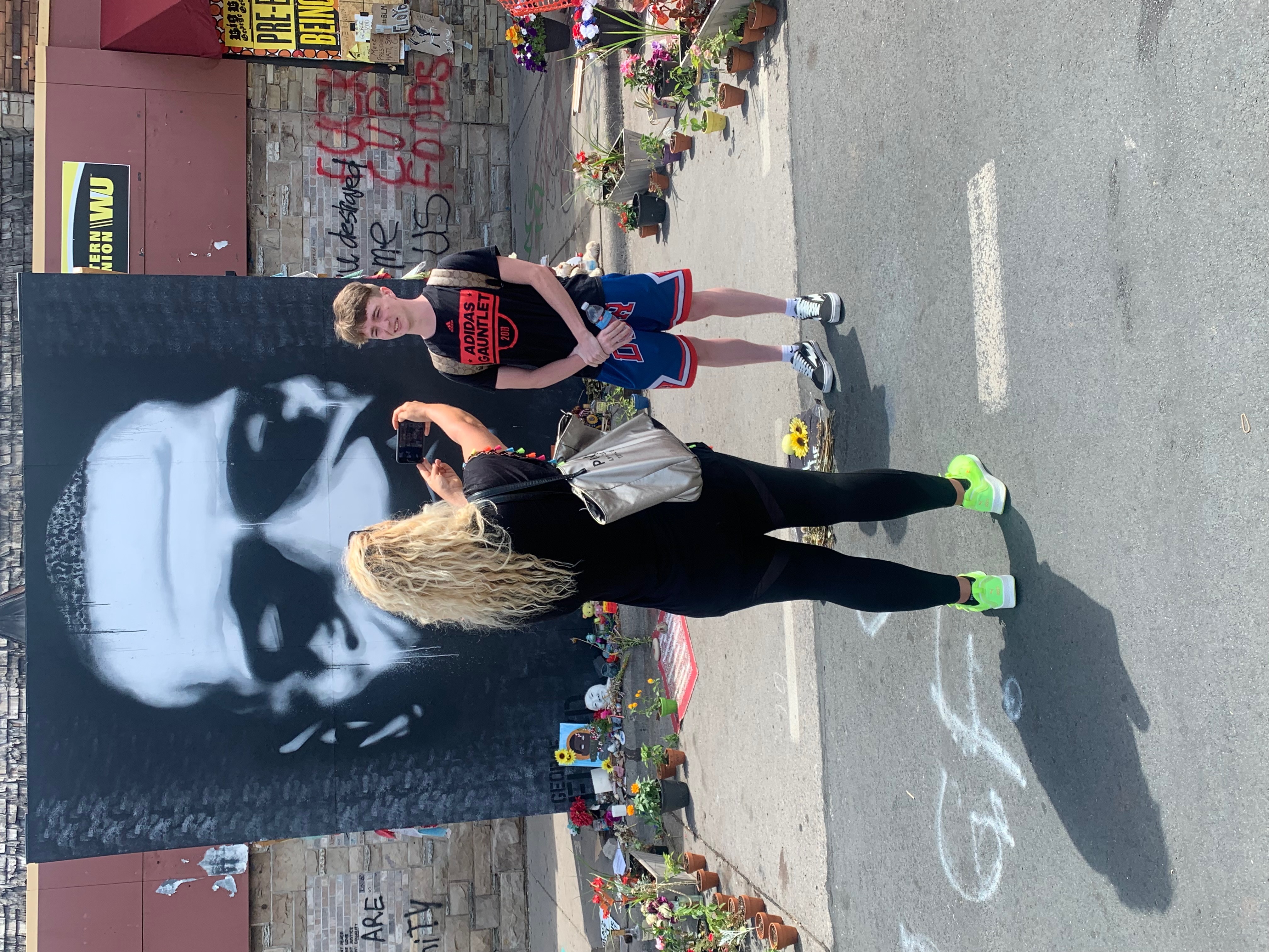 Participant standing for a photo at a community memorial mural